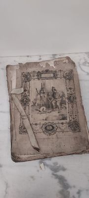 an old book sitting on a marble counter top