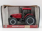 the toy tractor is in the box on the white surface
