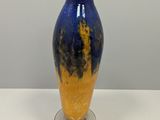 a blue and yellow vase sitting on a white table