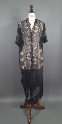 une photo d'une chemise noire et blanche posée sur un présentoir pour mannequin