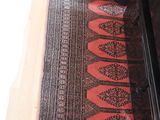 a rug on the floor next to a chair in a room