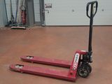 un chariot élévateur rouge garé dans un garage, avec la porte du garage en arrière-plan