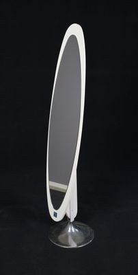 un miroir posé sur un pied, sur un fond noir