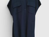 a black shirt hanging on a white wall with a black hanger