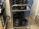 many pots and pans stacked on a cart in the kitchen