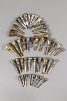 un assortiment de pavillons de trompette en laiton et en argent sur un fond blanc
