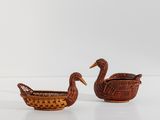 deux petits paniers en osier ornés de canards, posés sur une surface blanche