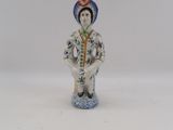 porcelain figurine of a woman sitting on a blue and white pedestal