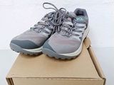a pair of gray shoes sitting on top of a cardboard box
