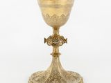 un calice ancien en laiton orné d'une croix sur le socle