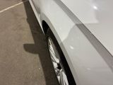 a close up of a white car parked in a parking lot