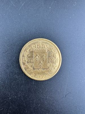 gros plan d'une pièce d'or sur une surface noire