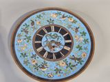 a clock that is sitting on the wall next to a vase
