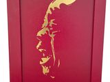 un cadre photo rouge orné d'une peinture à la feuille d'or représentant le visage d'un homme