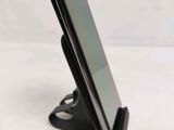 a close up of a cell phone on a stand on a white surface