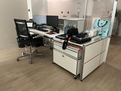un bureau avec deux ordinateurs et une chaise dans la chambre