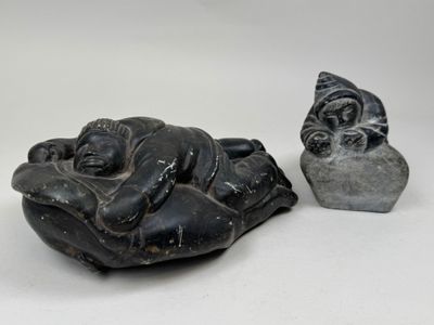 a small statue of a sleeping buddha next to a smaller statue of a sleeping buddha