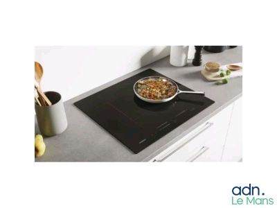 une casserole contenant de la nourriture posée sur une plaque de cuisson, sur le plan de travail