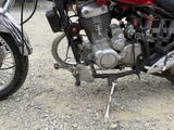 two motorcycles parked next to each other on a gravel road