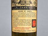 une vieille bouteille de vin posée sur une table blanche