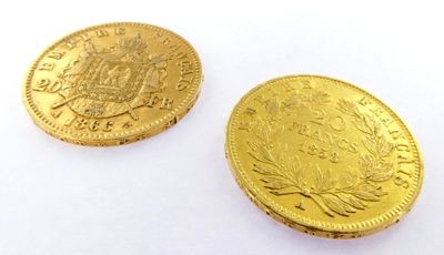 two pieces of gold coins sitting next to each other on a white surface