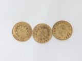 three gold coins, one of which is a sovereign and one of which is a sovereign