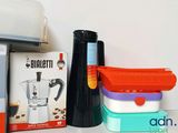 a stack of containers sitting on a counter next to a coffee maker