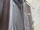 a person holding a black purse with a zipper on it