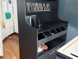 a black cabinet with wine glasses on it in the kitchen