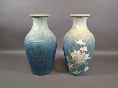 deux vases avec des fleurs peintes dessus, posés sur une table