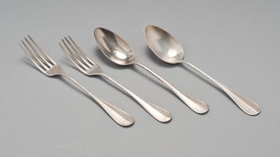 un ensemble composé de cinq cuillères et d'une fourchette posé sur une table