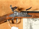 an old gun with a wooden case and a tag on it