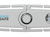 a close up of a white device with a safety button on it