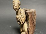 an old wooden statue of a man with a hat on his head