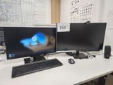 deux écrans d'ordinateur posés sur un bureau avec un clavier et une souris