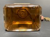 a bottle of perfume sitting on a table next to a hand