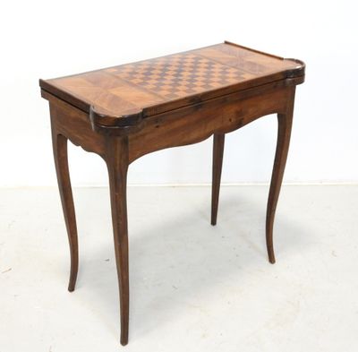 une vieille table en bois sur laquelle est posé un échiquier