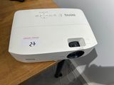 a white projector sitting on top of a wooden table