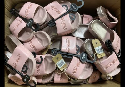 de nombreuses paires de chaussures dans une boîte, avec leurs étiquettes