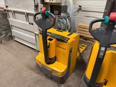 Deux chariots élévateurs jaunes sont garés devant la porte d'un garage