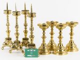 five gold candlesticks and a green box