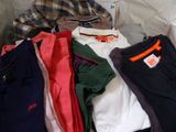 a pile of clothes that is sitting on a bed