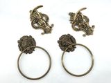 three antique brass towel rings with lion heads on them