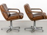 two brown leather office chairs with chrome steel legs and arms
