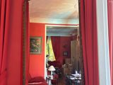 une pièce rouge avec des rideaux rouges et un miroir accroché au mur