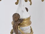a white and gold vase with a statue on top of it