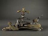 silver and gold figurine of a man on a horse with a gun in his hand
