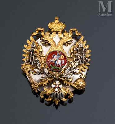 an image of a gold and red broochle on a black surface