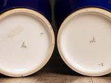 two blue vases sitting on top of a wooden table next to each other