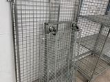 several metal cages are lined up against a wall in a warehouse